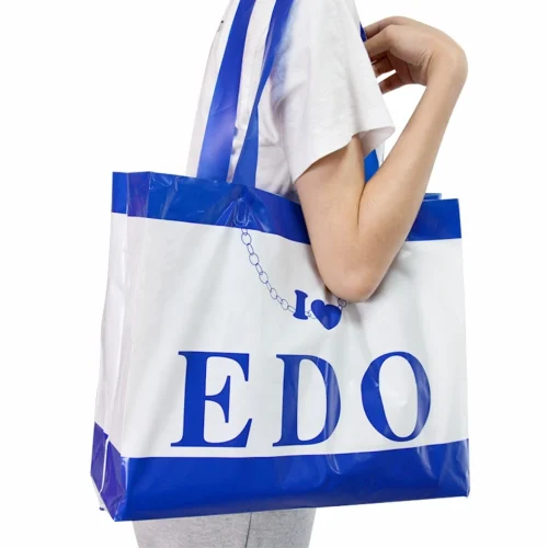 Model wearing a large soft loop handle shopping bag over their shoulder for convenience.